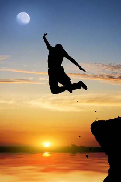 Siluetten av den person som hoppar på en nedgång — Stockfoto