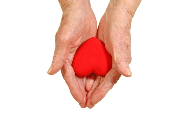 Руки пожилой женщины, держащей форму сердца — стоковое фото