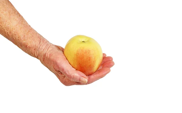 An elderly woman's hand with apple — Stock Photo, Image