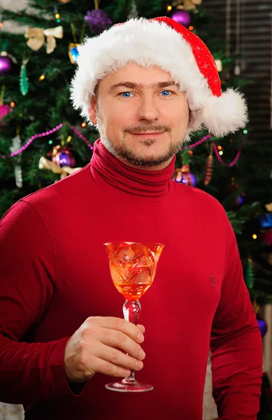 Jovem Papai Noel com um copo em uma árvore de Ano Novo — Fotografia de Stock