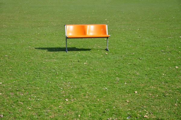 Stock image Orange bench on lawn