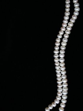 White pearls on the black silk as background clipart