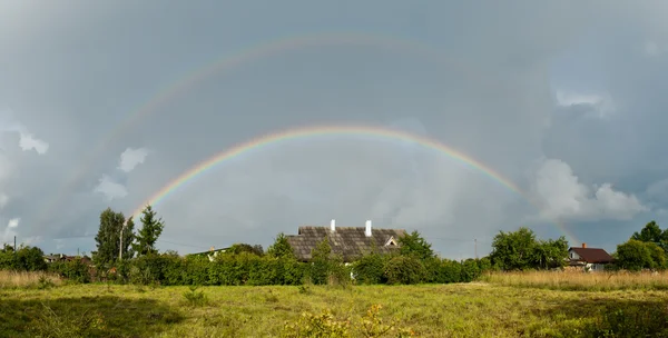 Rainbow over the village — Stock Photo, Image