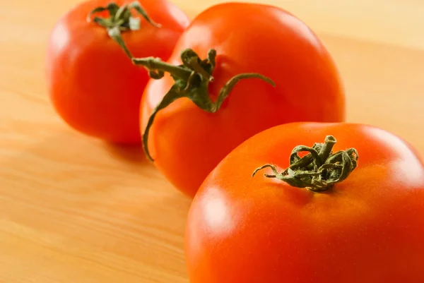 Three tomatoes on the table. — Stock Photo, Image