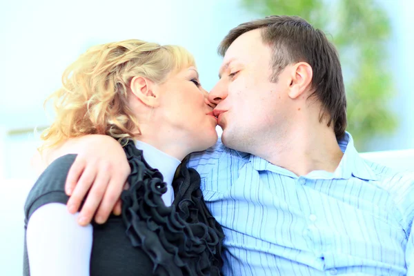 Retrato de um homem carinhoso beijando sua esposa sentada na cama em casa — Fotografia de Stock