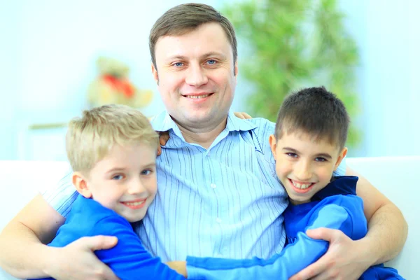 Portret ojca i dwóch synów na kanapie — Zdjęcie stockowe