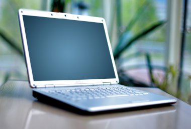 Thin laptop on office desk clipart