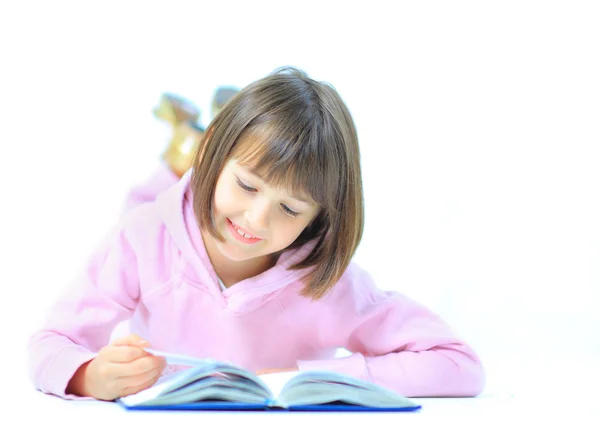 Stock image Little girl lieing on the floor and reading book