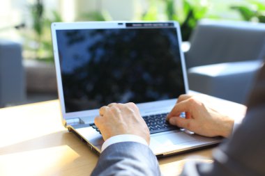 Person Typing on a modern laptop in an office clipart