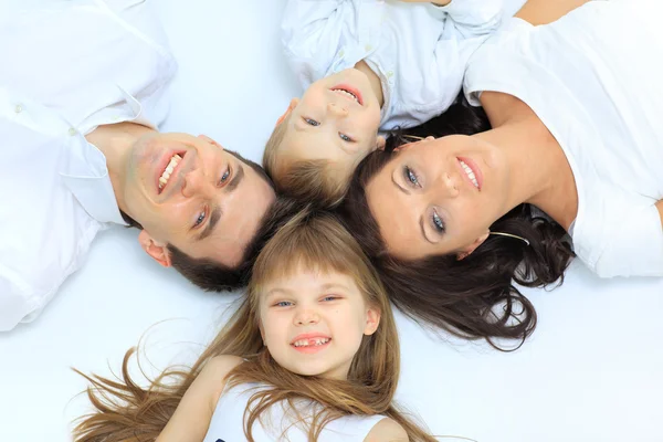Щаслива сім'я, мати, батько і дочка відпочивають на білому ліжку — стокове фото