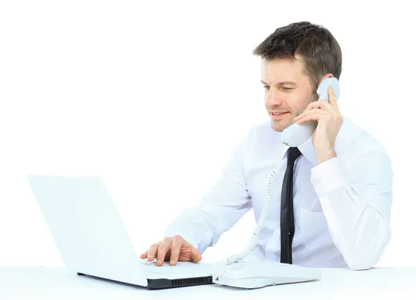 Homem de negócios feliz no telefone celular na frente do laptop — Fotografia de Stock