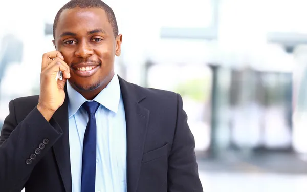 Lachende zakenman aan de telefoon in zijn kantoor — Stockfoto