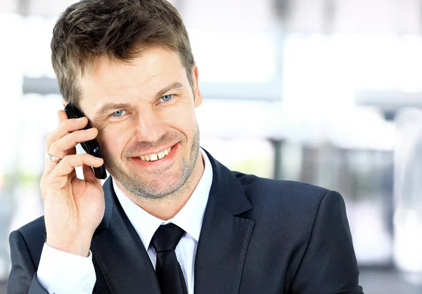 Homme souriant utilisant un téléphone de bureau — Photo