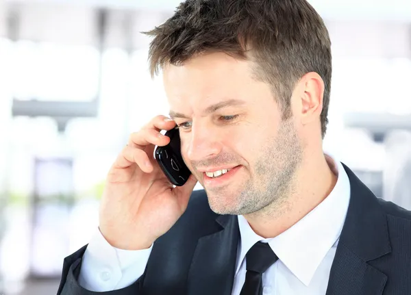Χαμογελαστός άνθρωπος χρησιμοποιώντας ένα τηλέφωνο γραφείο — Φωτογραφία Αρχείου