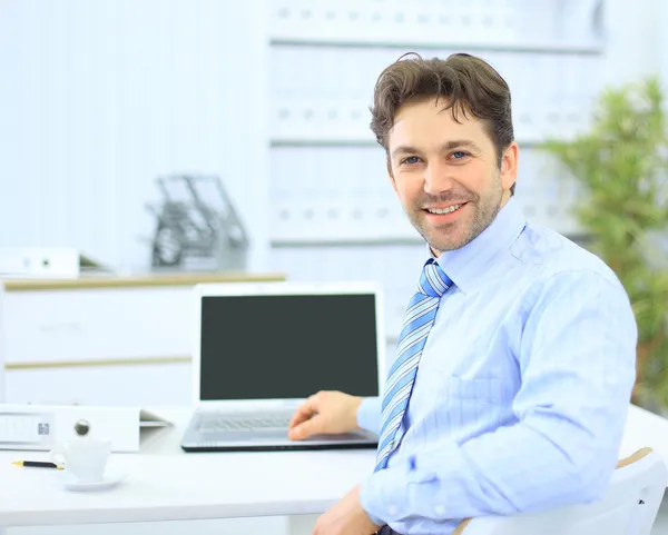 商务男人坐在他的办公桌在办公室用一台笔记本电脑 — 图库照片
