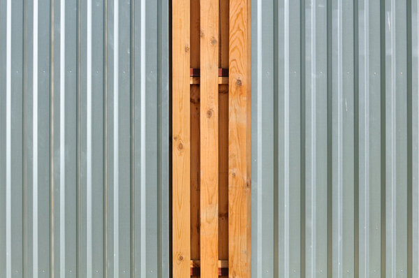 A metal fence with wood inserts as a background