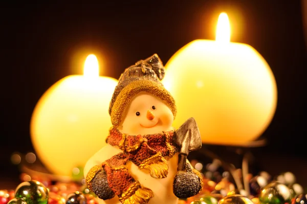 Снеговик Фигурина и горящие свечи — стоковое фото