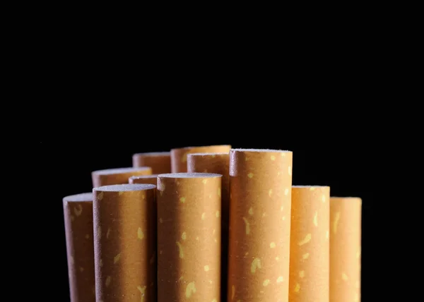 Filtros de cigarrillos sobre fondo negro —  Fotos de Stock
