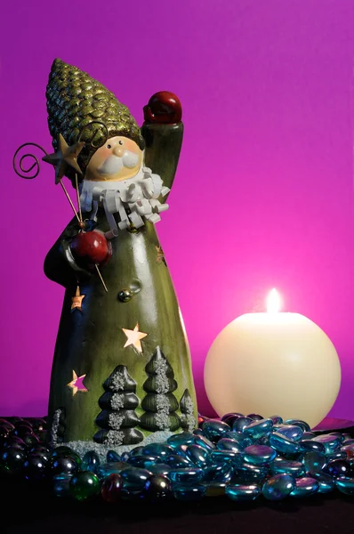 Санта-Клаус и горящая свеча на волшебном фиолетовом фоне — стоковое фото