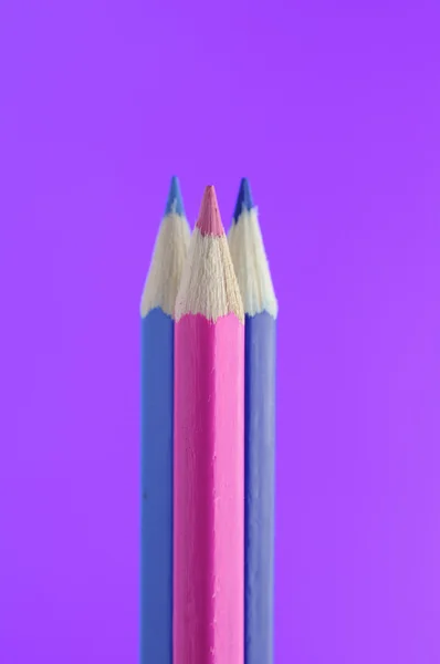 紫色背景上的蓝色和粉红色铅笔 — 图库照片