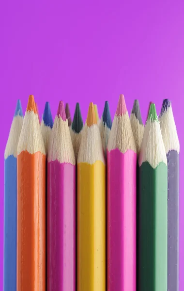Lápis coloridos sobre fundo roxo brilhante — Fotografia de Stock
