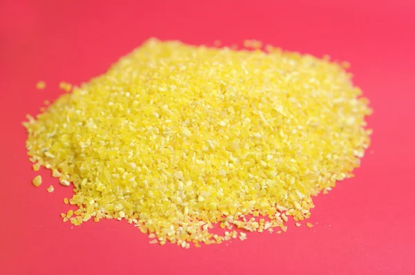 Pile of Corn Grits on Pink Background — Stock Photo, Image