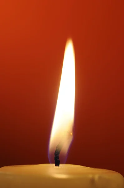 Chama de vela ardente no fundo vermelho — Fotografia de Stock
