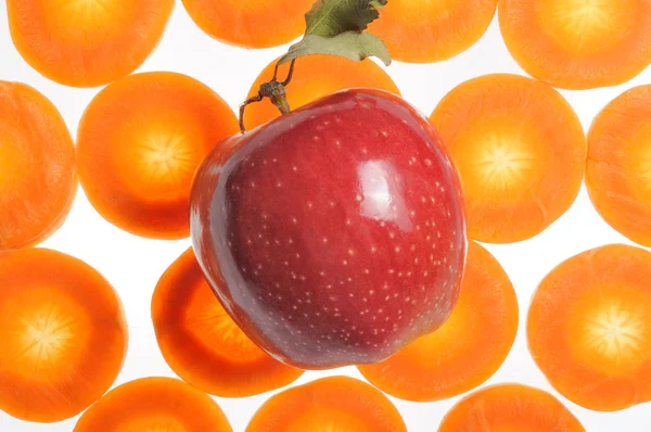 Rött äpple på morot bakgrund — Stockfoto
