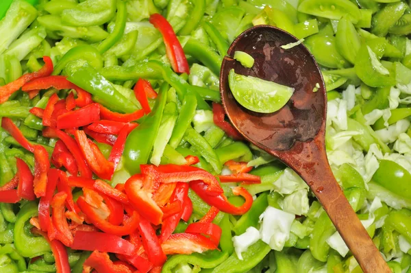 Salat aus Paprika, grünen Tomaten und Kohl mit hölzernen — Stockfoto