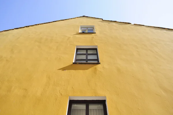Κίτρινο σπίτι πρόσοψης με παράθυρα — Φωτογραφία Αρχείου