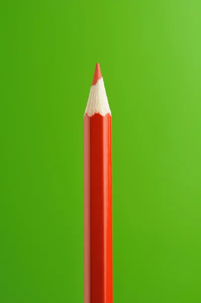 Czerwony ołówek na zielonym tle — Zdjęcie stockowe