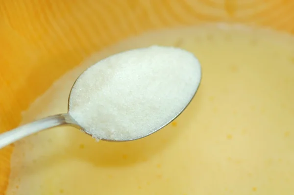 Weißer Zucker in Schüssel mit geschlagenen Eiern hinzugefügt — Stockfoto