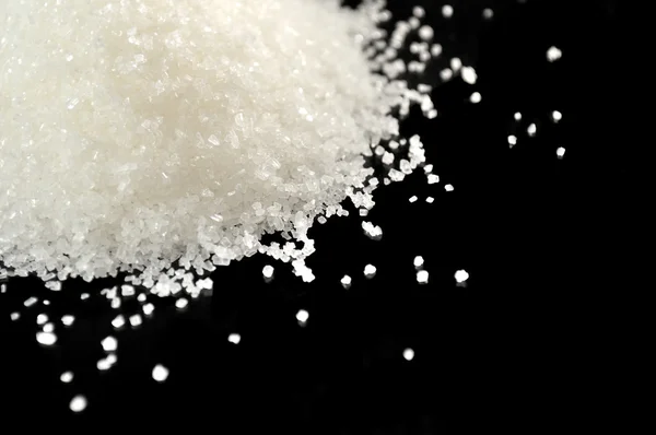Haufen Zucker in Großaufnahme auf schwarzem Hintergrund — Stockfoto