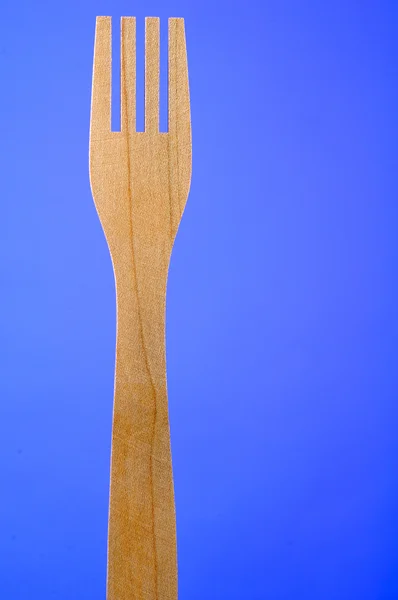 Houten vork op blauwe achtergrond met kopie ruimte — Stockfoto