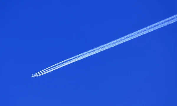 Vliegtuig in blauwe hemel met condensatie (damp) Trail — Stockfoto