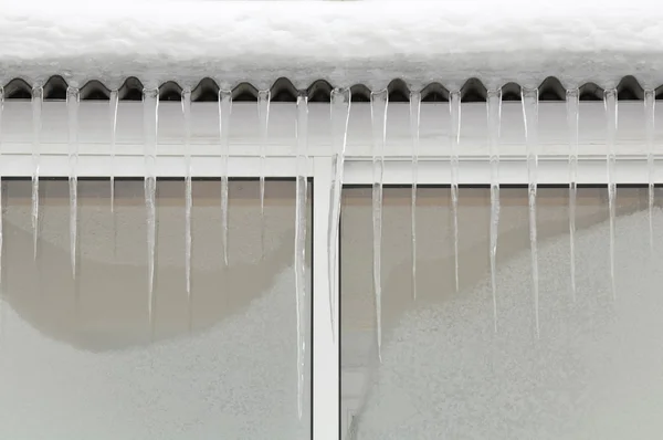 Buz sarkıtları kışın çatı üzerinde — Stok fotoğraf