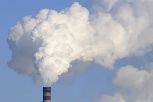Smokestack industrial com fumaça pesada no fundo do céu azul — Fotografia de Stock
