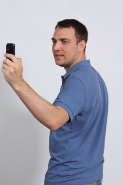 Men posing for a photograph taken from his cell phone clipart