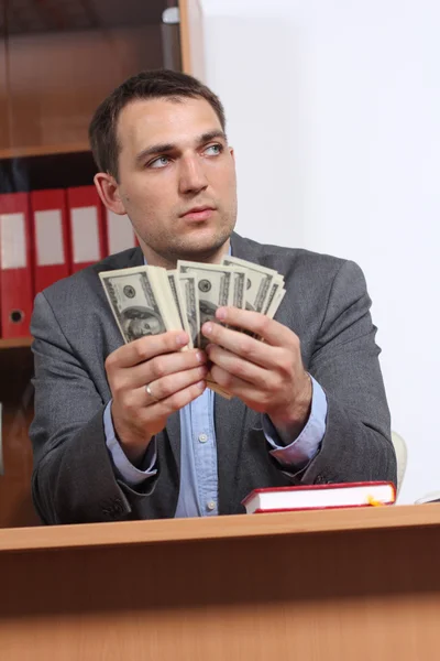 En ung man med dollar i händerna — Stockfoto