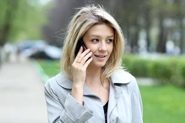 Ung kvinna pratar på mobiltelefon — Stockfoto