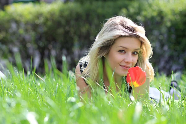 Blondine liegt auf Wiese im Park — Stockfoto