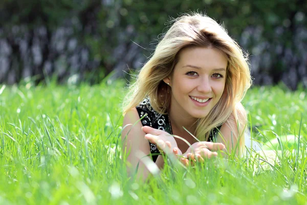 Blonde lying on grass field at the park — Stock Photo, Image
