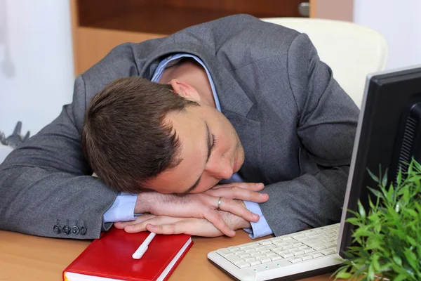 Ein Mann, der am Arbeitsplatz schläft — Stockfoto