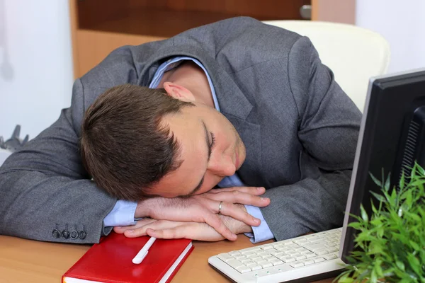 Ein Mann, der am Arbeitsplatz schläft — Stockfoto