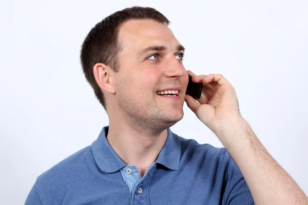 Lachende jonge man op zijn mobiele telefoon — Stockfoto