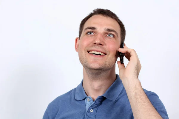 Lachende jonge man op zijn mobiele telefoon — Stockfoto