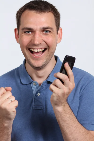若い男が彼の携帯電話に笑みを浮かべてください。 — ストック写真