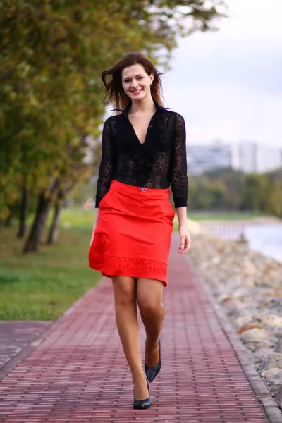 Walking woman red skirt — Stock Photo, Image