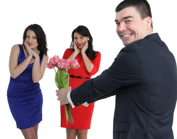 Hombre con un ramo de flores y dos mujeres jóvenes — Foto de Stock