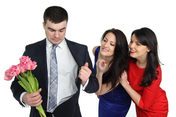 Man med en bukett blommor och två unga kvinnor — Stockfoto